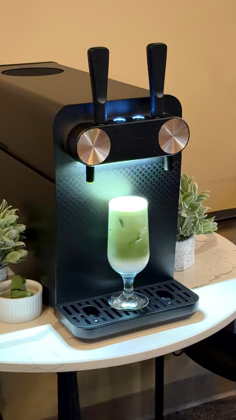 Nitro matcha latte poured fresh under the tap, topped with a creamy foam head