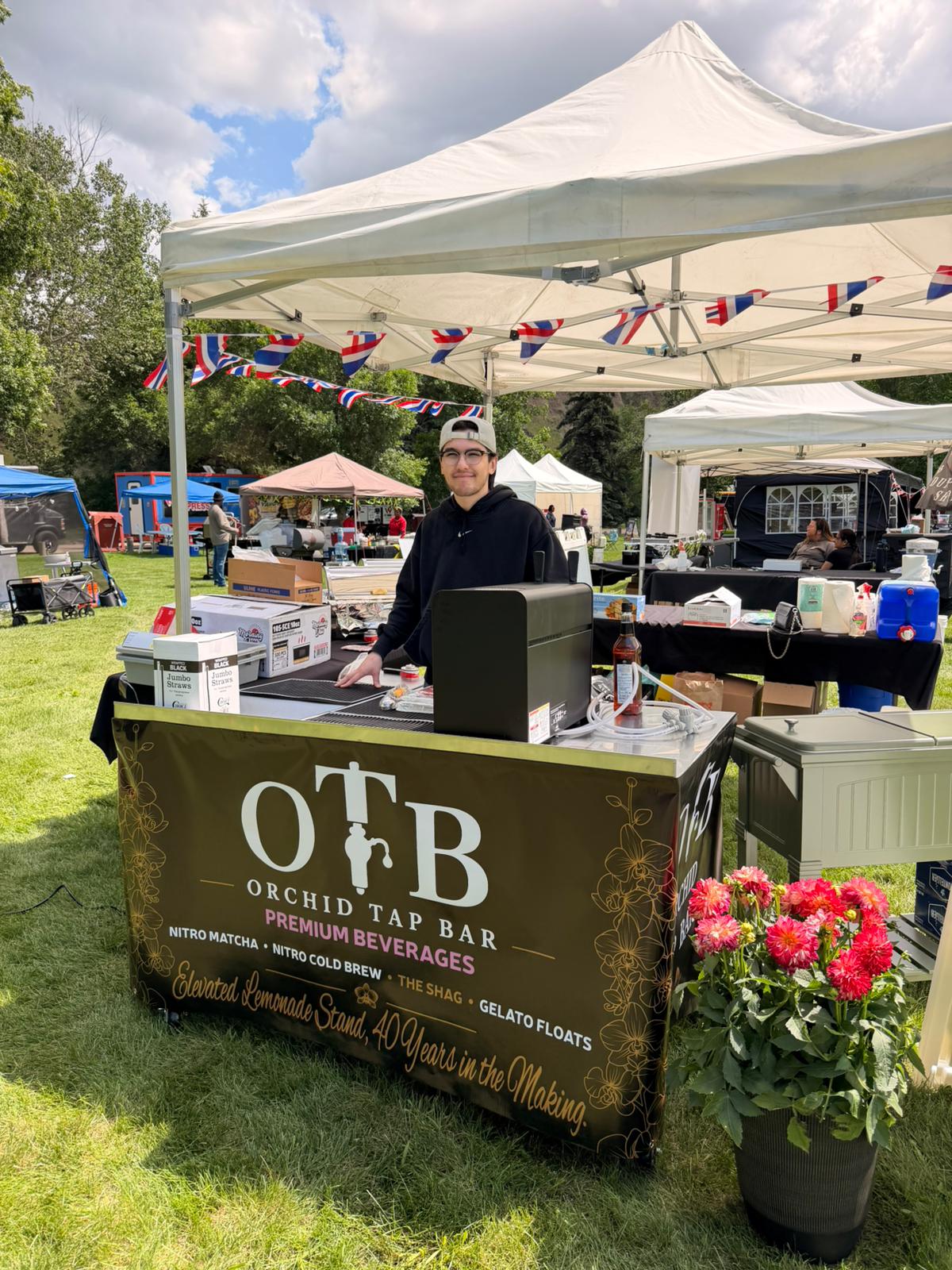 The Orchid Tap Bar booth set up and serving at an outdoor community festival