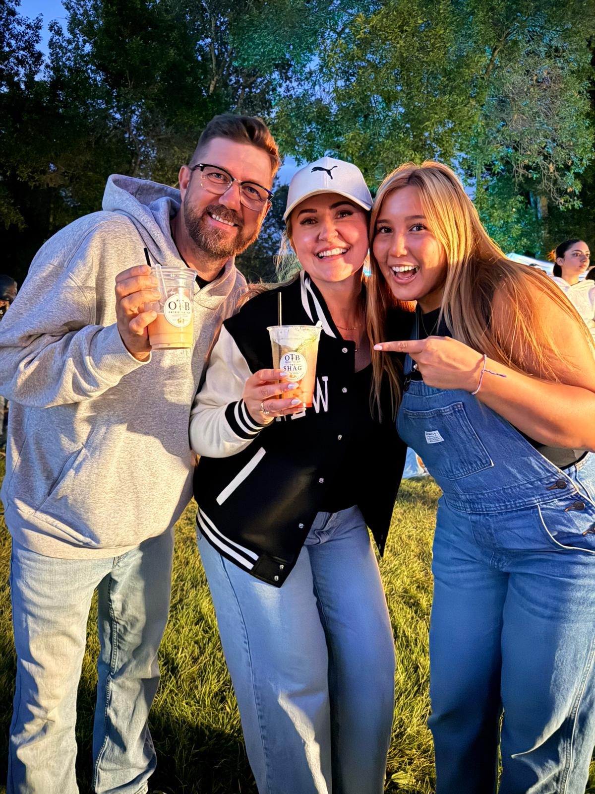 Friends laughing together with OTB drinks in hand at an evening celebration