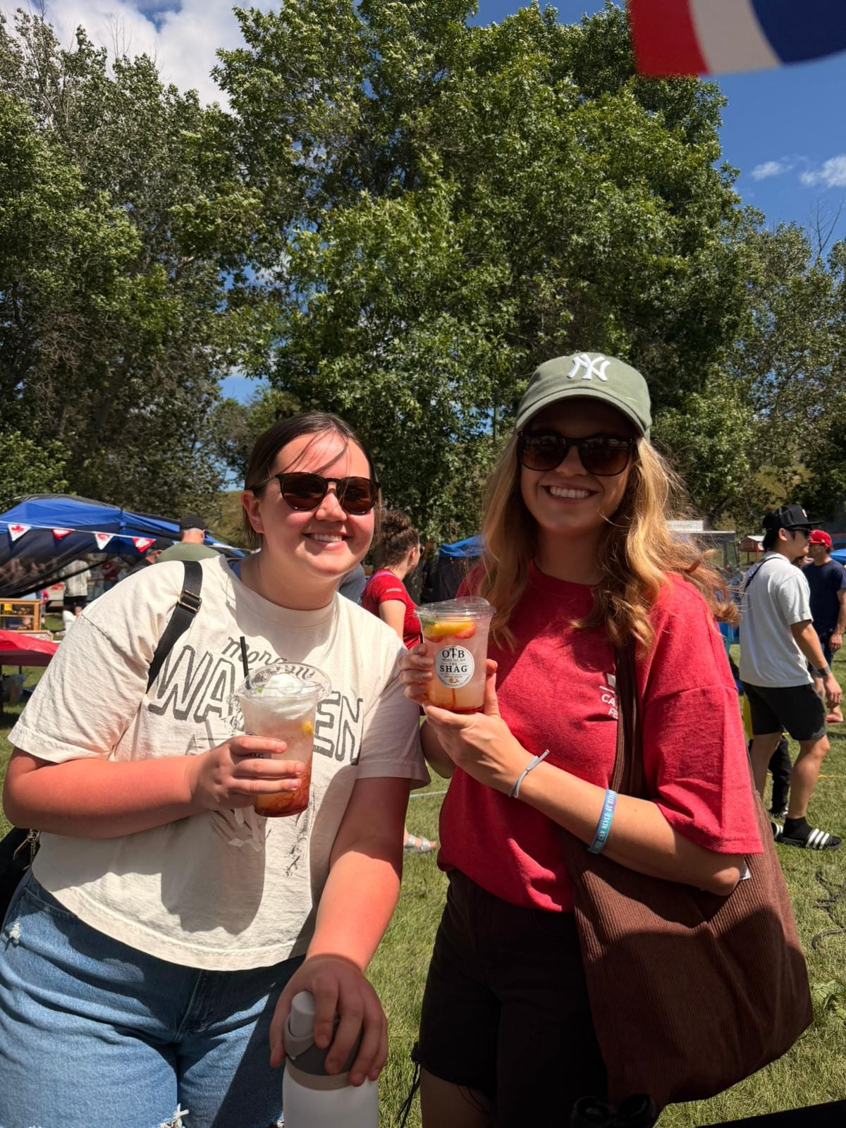 Two friends in sunglasses toasting with OTB Shag lemonades