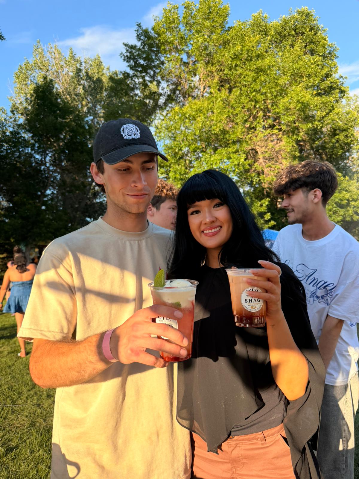 Three friends holding OTB Shag lemonades together in the sunshine
